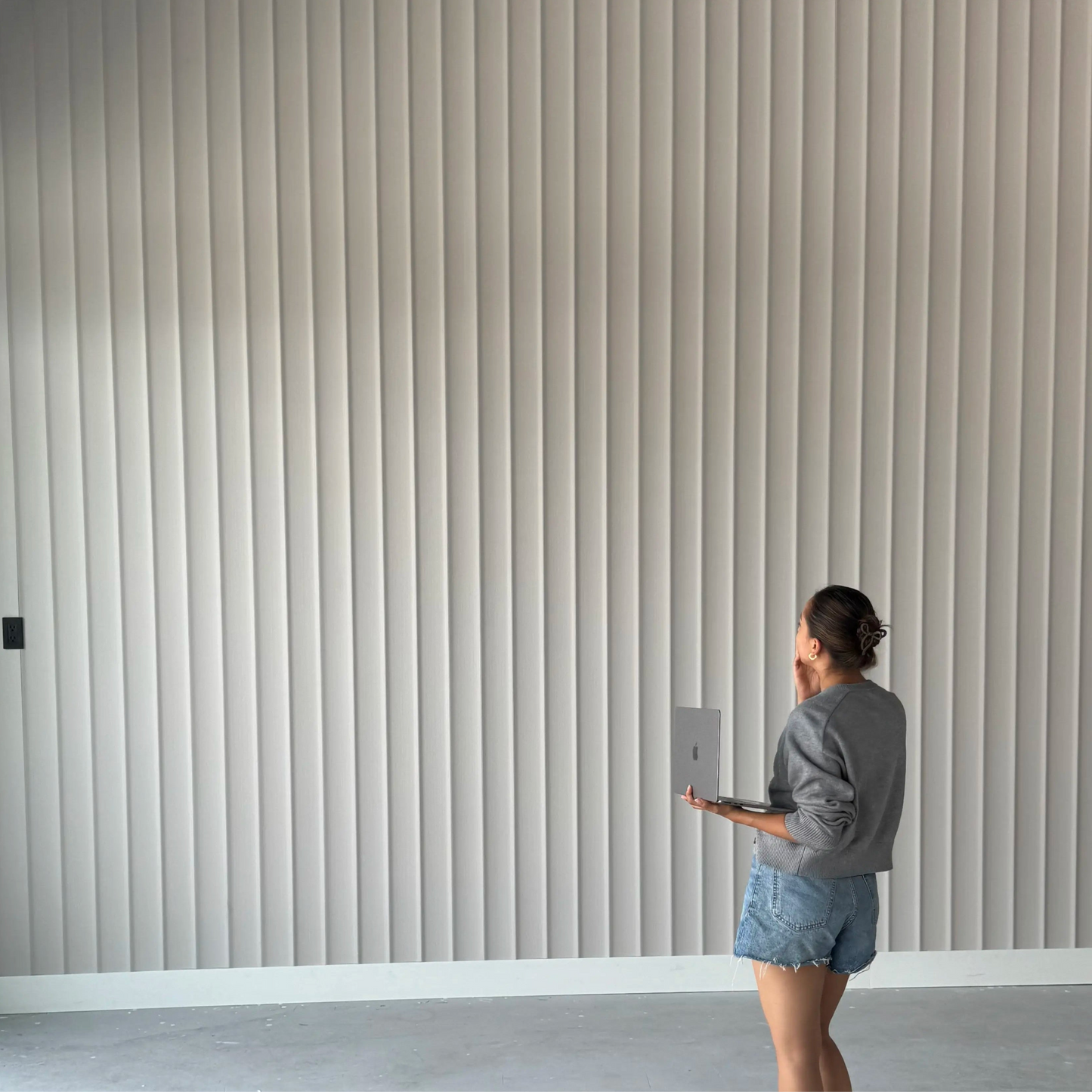 Light decorative slatted wall panels installation in modern interior