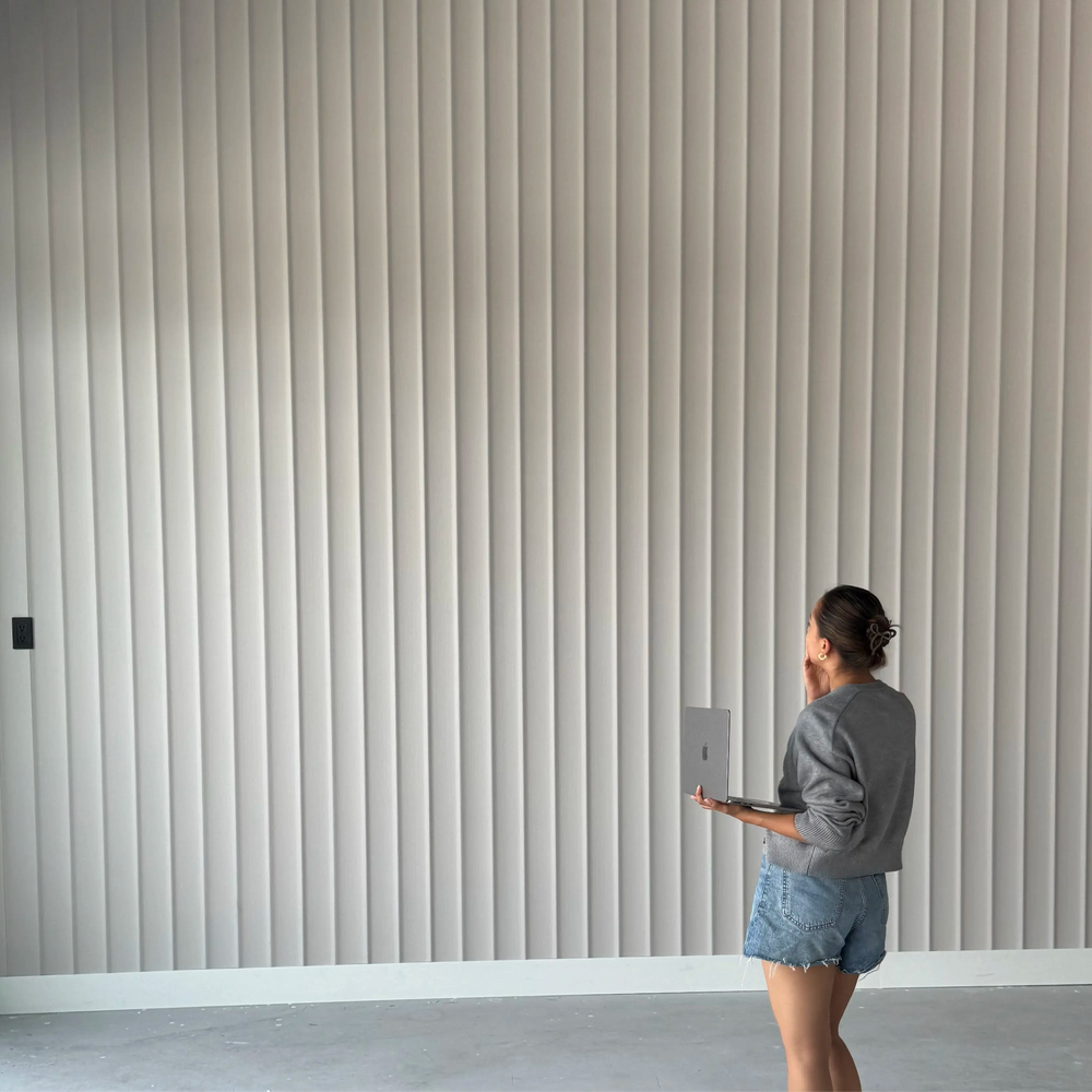 Light decorative slatted wall panels installation in modern interior