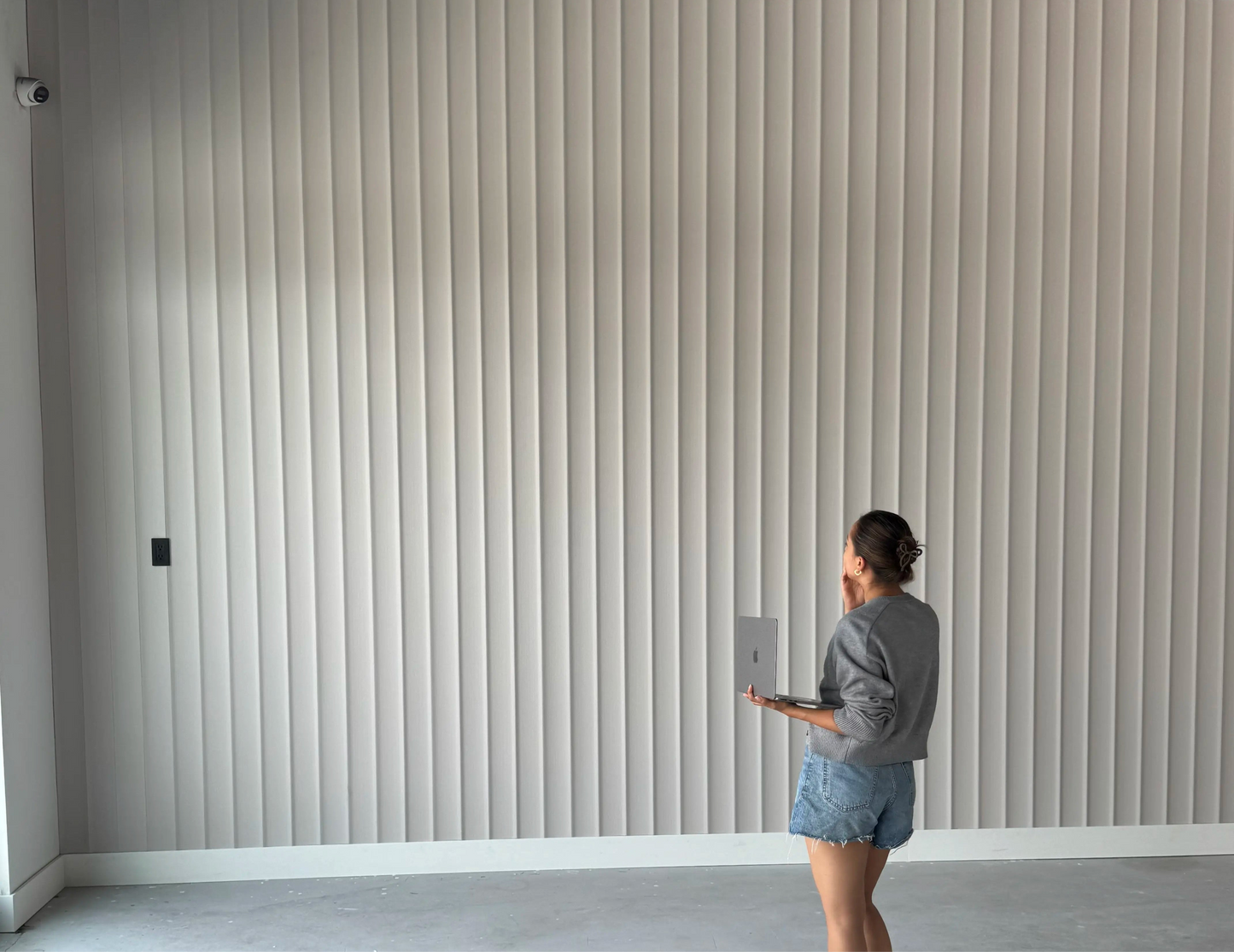 Light decorative slatted wall panels installation in modern interior